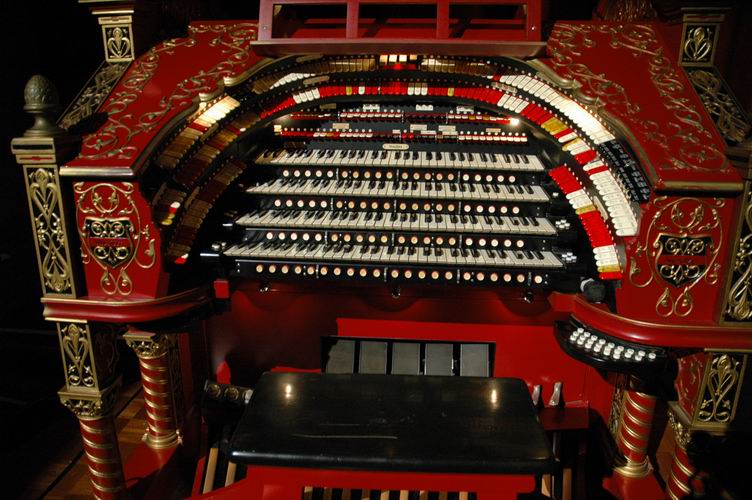 The organ console key manuals with pistons, stop rails, and expression pedals.