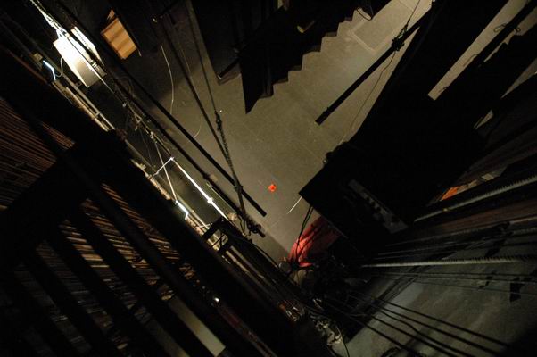 On the ladder platform, looking out over the railing down to the stage.